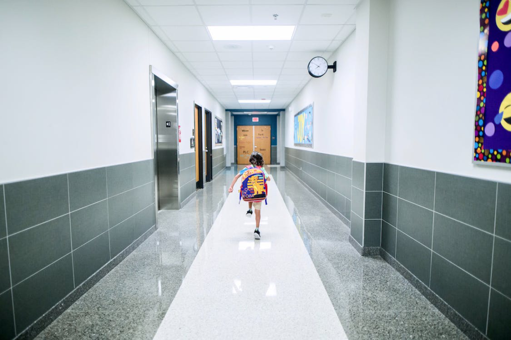 A student runnign through a school corridor.