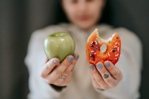 Woman Holding a Donut and an Apple