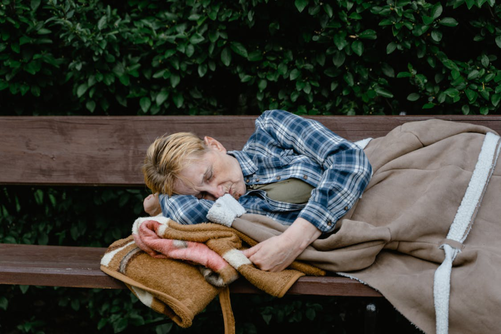 A homeless woman sleeping on a bench