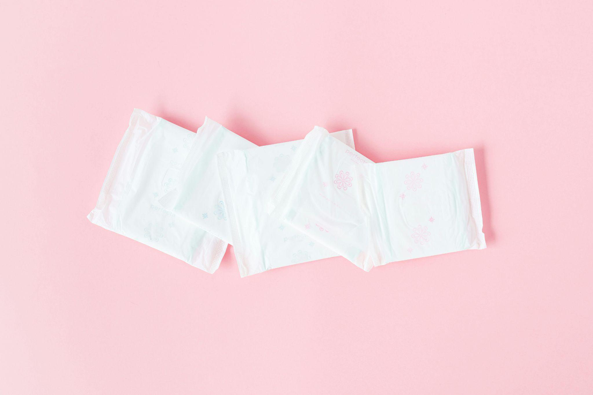 This photo shows sanitary pads and panty liners on a pink background.