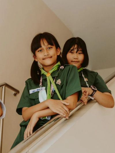 This image shows two school girls standing on the stairs.
