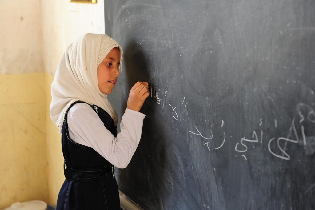 This photo shows a schoolgirl writing something on a blackboard.